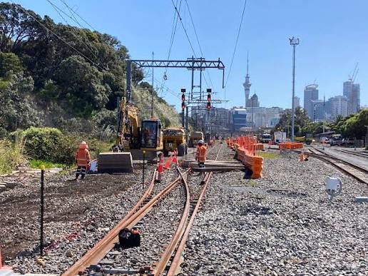 Rail corridor and utility service works in Auckland with track panels, excavator and overhead line equipment
